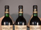 four bottles of wine are lined up in a row on a table