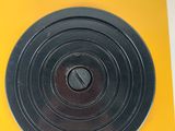 a small yellow object with a black disc on it