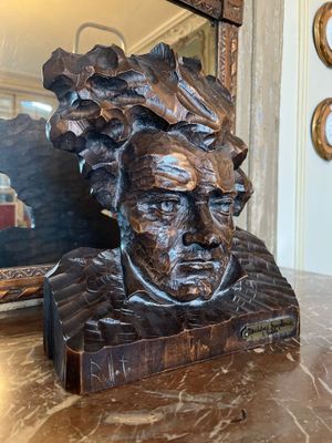 a statue of a man sitting on a table next to a mirror