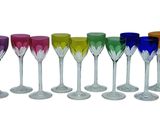 six verres à vin de couleurs différentes sont alignés
