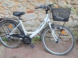a bicycle parked next to a stone wall with a basket on the back