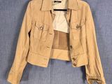 une veste beige suspendue à un cintre sur un mur bleu