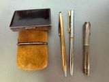 three different types of pens and a case on a table