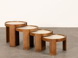 trois tables en bois aux plateaux blancs sont posées sur un sol en béton