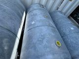 three metal tanks sitting next to each other on the ground