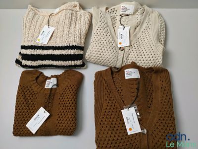 three sweaters and a bag are sitting on a table