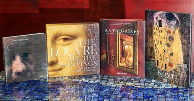 cinq livres posés sur une table recouverte d'une nappe bleue