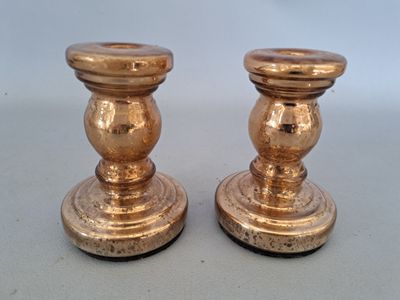 deux bougeoirs en or posés sur une table