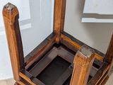 a wooden chair that is sitting on a tile floor