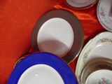 many plates and bowls sitting on a red table cloth