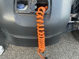 a close up of a car ' s front bumper with an orange hose attached to it