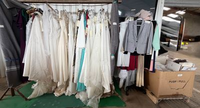 beaucoup de vêtements suspendus à une étagère dans une pièce