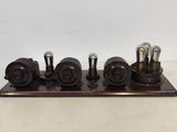 an old fashioned steam engine on a wooden stand with four valves