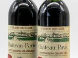 two bottles of wine sitting next to each other on a white surface