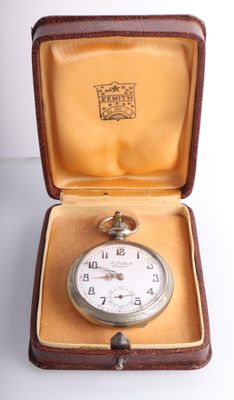 une petite montre de poche dans un écrin posé sur une table