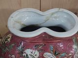 a pink vase with a flower design on it