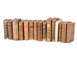 plusieurs vieux livres sont empilés sur une surface blanche