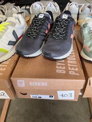 several pairs of running shoes sitting on top of boxes in a store