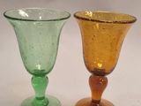 two glass goblets sitting next to each other on a table
