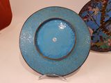 a blue plate with a gold rim and a blue plate with a bird on it