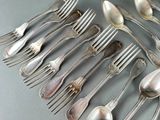 a lot of silver spoons and forks on the table