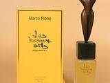 un gros plan sur un flacon de parfum à côté d'une statue