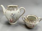 a white tea pot and a white tea pot on a table