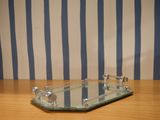 a glass tray on a wooden table with a striped wall behind it