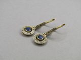 a pair of gold earrings with blue stones on them