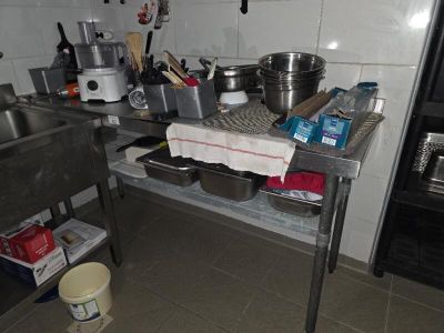 une cuisine équipée d'un évier, d'une cuisinière et d'autres éléments posés sur le plan de travail