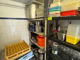 de nombreuses casseroles et poêles sur les étagères de la cuisine