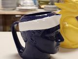 two mugs sitting on a table with a pineapple on top of them