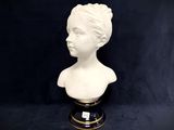 white bust of a woman on a black base with a black background