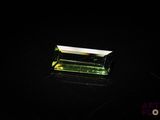 a green tourmaline gems on a black surface