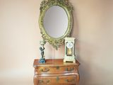 a dresser with a mirror and a clock on it
