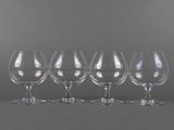 six verres à vin vides alignés sur fond gris