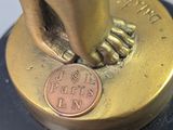 a gold statue of a hand holding a coin