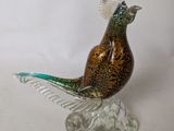 a glass bird that is sitting on top of a rock