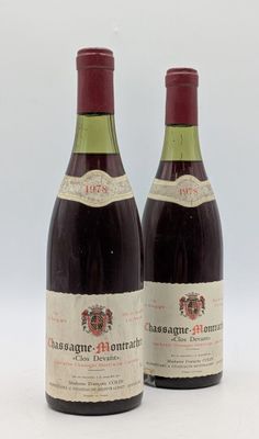 deux bouteilles de vin rouge posées l'une à côté de l'autre sur une surface blanche