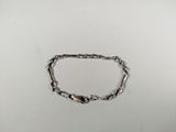 a close up of a silver chain bracelet on a white surface