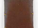 an old brown leather book with yellow studs on it