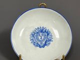 a blue and white plate with a lion on it sitting on a table