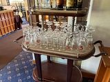 a bar cart with a lot of wine glasses on it