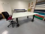 un bureau avec une chaise devant, dans une pièce remplie de tissus