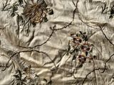 a close up of a bed with a floral design on it