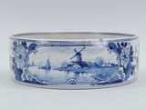 a picture of a blue and white bowl with a windmill in the background