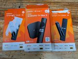 two boxes of remotes sitting on top of a wooden table