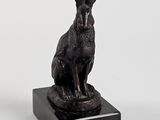 statue d'un lapin assis sur un socle en marbre, sur fond blanc