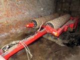 a red trailer with two logs on it in a room