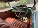 a green car with a brown leather seat and steering wheel